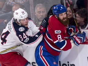 Montreal Canadiens' Jordie Benn, right, is checked by Columbus Blue Jackets' Josh Anderson during first period action in Montreal on Tuesday. It was Benn's first game with the Habs after being traded to Montreal from Dallas.