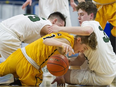 Walnut Grove's Ty Rowell and Luke Adams cover Kelowna's Parker Johnstone as he reaches for a loose ball in the final of the 4A 2017 BC Boys High School Basketball Championship. Walnut Grove defeated Kelowna 78-65.
