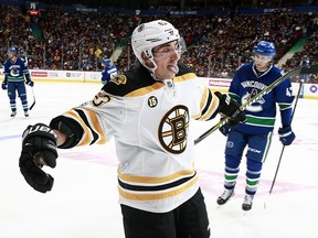 Drew Shore looks on as Brad Marchand celebrates one of his three goals against the Canucks on Monday night.