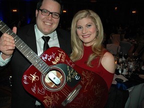 Kidney Gala auctioneer Tyler Olson and master of ceremonies Norma Reid display one of the coveted items at the live auction in the Hotel Vancouver earlier this month — a guitar signed by Canadian musicians in support of kidney research.