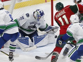 Vancouver Canucks goalie Richard Bachman, left, stops a shot by Minnesota Wild's Zach Parise during the third period of an NHL hockey game Saturday, March 25, 2017, in St. Paul, Minn. The Canucks won 4-2.