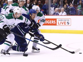 Nikita Tryamkin vies for the puck with Esa Lindell and John Klingberg.