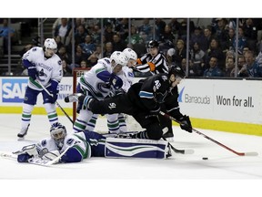 San Jose Sharks' Tomas Hertl (48) leaps over sprawled Vancouver Canucks goalie Ryan Miller during the third period of an NHL hockey game Thursday, March 2, 2017, in San Jose, Calif.