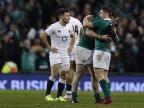 TOPSHOT - Players react at the final whistle in the Six Nations international rugby union match between Ireland and England at the Aviva Stadium in Dublin on March 18, 2017.