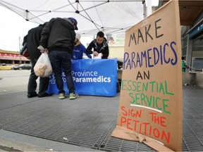 People sign a petition in Vancouver calling for B.C. paramedics to be granted the same bargaining rights, wages and resources as police and firefighters.