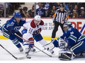 Vancouver Canucks centre Bo Horvat wraps his stick around Montreal Canadiens' Brendan Gallagher in front of Canucks goalie Ryan Miller in recent NHL action in Vancouver.