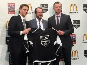 Los Angeles Kings president Luc Robitaille, left, holds up a team jersey with Anschutz Entertainment Group CEO Dan Beckerman, middle, and Kings general manager Rob Blake after a news conference Tuesday, April 11, 2017, in Los Angeles, Calif. Robitaille and Blake were promoted by the Kings after the firing of general manager Dean Lombardi and coach Darryl Sutter. (AP Photo/Greg Beacham)