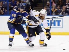 St. Louis Blues left wing Ivan Barbashev (49), of Russia, and Nashville Predators defenseman Ryan Ellis (4) battle for the puck during the second period in Game 2 of an NHL hockey second-round playoff series Friday, April 28, 2017, in St. Louis. (AP Photo/Jeff Roberson)