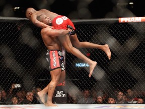 Light heavyweight champion Jon Jones is lifted up by Daniel Comier during their 2015 UFC 182 bout in Las Vegas.