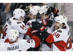 The Senators celebrate after defeating the Bruins 3-2 in overtime to clinch the series.