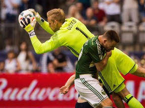 Whitecaps keeper David Ousted makes the save as Portland Timbers Jack McInerney makes contact during MLS action at Vancouver in May 2016. Ousted and the Caps face the Timbers on Saturday.