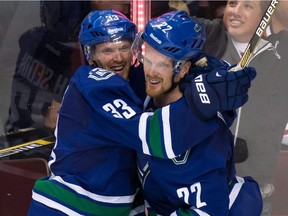 FILE - This Oct. 30, 2014, file photo shows Vancouver Canucks' Daniel Sedin, right, celebrating with his twin brother Henrik Sedin, both of Sweden, after scoring the winning goal against the Montreal Canadiens at an NHL hockey game in Vancouver.