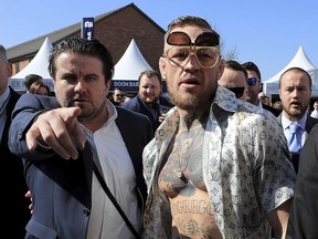 Irish fighter Conor McGregor, right, arrives on Grand National Day of the Grand National Festival at Aintree Racecourse in Liverpool, England, on Saturday. McGregor has taken a break from UFC to chase a big money fight with Floyd Mayweather, leaving the UFC without its biggest current name.