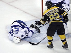 Tampa Bay Lightning defenceman Jake Dotchin  lies on the ice after being speared in the groin by Bruins left wing Brad Marchand during the first period of an NHL hockey game in Boston, Tuesday, April 4, 2017. The NHL has Marchand for the Bruins' final two games of the regular season.