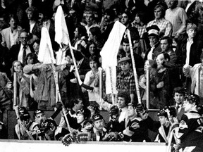 Roger Neilson and two other Vancouver Canuck players raise a stick and a white towel in protest over calls made by referee Bob Myers in a 4-1 game 2 loss to the Chicago Blackhawks in the 1982 Campbell Conference Hockey Final.  Neilson was ejected for his actions in the loss and "towel power" was born.