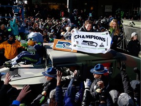 General Manager John Schneider of the Seattle Seahawks waves to fans during a parade to celebrate their victory in Super Bowl XLVII on February 5, 2014.