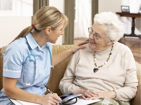 An elderly woman speaks with a health visitor at the senior's home.