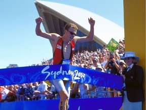 Simon Whitfield of Canada crosses the line to win gold in the Men's Triathlon at the Opera House on Day Two of the Sydney 2000 Olympic Games in Sydney, Australia.