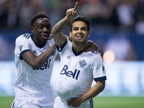Vancouver Whitecaps' Alphonso Davies, left, and Cristian Techera celebrate Techera's goal during first half MLS soccer action against the Los Angeles Galaxy, in Vancouver, B.C., on Saturday, April 1, 2017.