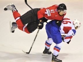 Switzerland's Luca Sbisa (L) flies above Norway's Mathis Olimb during their IIHF Ice Hockey World Championship group F qualification match in Kosice city on May 5, 2011.