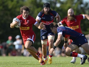 Team Canada's Taylor Paris (left) keeps the ball away from Team USA's Blaine Scully (right) and Danny Barrett during the first half of an international rugby test match in Ottawa on Saturday, Aug. 22, 2015. USA won 42-23.