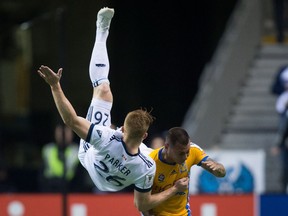 Vancouver Whitecaps' Tim Parker, left, falls to the ground after colliding with Tigres' Eduardo Vargas during first half, second leg, CONCACAF Champions League soccer semifinal action in Vancouver, B.C., on Wednesday, April 5, 2017.