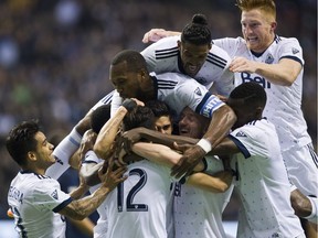 Whitecaps Matias Laba is smothered by teammates after he scored against the L.A. Galaxy in a regular-season MLS game at B.C. Place Stadium in Vancouver on Saturday.