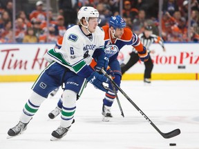 Brock Boeser of the Vancouver Canucks carries the puck against the Oilers' pursuers April 9 at Rogers Place in Edmonton.