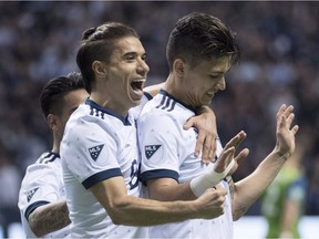 Whitecaps Fredy Montero, right, celebrates his second goal with teammate Nicolas Mezquida, during the second half of MLS action against the Seattle Sounders in Vancouver on Friday.