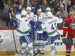 Winger Brock Boeser (third from left) is the centre of attention after scoring his first career NHL goal against the host Minnesota Wild on March 25. Boeser went on to score four goals in his nine NHL games to end the season.