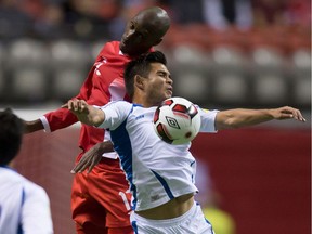 El Salvador's Andres Flores, front, and Canada's Atiba Hutchinson vie for the ball during FIFA World Cup qualifying soccer action in Vancouver on Sept. 6, 2016.