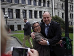 B.C. Green party Leader Andrew Weaver, right, and Green candidate Roy Sakata take a picture together following a news conference in the rose garden on the legislature grounds in Victoria on May 10.