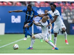 Montreal Impact's Ballou Tabla, left, leaps past Vancouver Whitecaps Marcel de Jong, centre, and Alphonso Davies during their MLS game last season. De Jong and Davies have been called up to play for Canada, while Tabla has yet to decide if he'll represent the Ivory Coast or Canada.