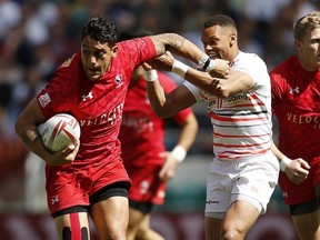 England's Dan Norton and Canada's Mike Fuailefau, left, on day two of the London Sevens.