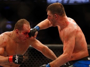 PHOENIX, AZ - DECEMBER 13:  Stipe Miocic (R) punches Junior dos Santos in their heavyweight bout during the UFC Fight Night event at the at U.S. Airways Center on December 13, 2014 in Phoenix, Arizona.  (Photo by Christian Petersen/Getty Images)