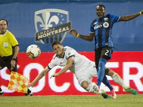 Montreal Impact defender Ambroise Oyongo kicks the ball away from Vancouver Whitecaps defender Jake Nerwinski during the second half of the second leg of Tuesday's Canadian Championship semifinal in Montreal. The Impact won.