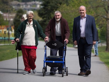 B.C. NDP Leader John Horgan, right, walks with voters Ruth and John La-Ballaster after driving them to a polling station to vote in the provincial election, in Coqutilam, B.C., on Tuesday May 9, 2017.