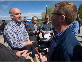 NDP Leader John Horgan, left, shakes hands with retiring B.C. Health Minister Terry Lake after Lake attended Horgan's campaign stop in Kamloops on Tuesday.