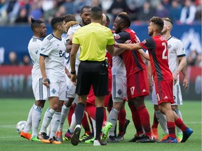 Toronto FC's Jozy Altidore (17) yells at Whitecaps' Kendall Waston, centre left, as the teams scuffle during MLS action in Vancouver on March 18.