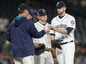 Starting pitcher James Paxton #65, right, of the Seattle Mariners is pulled from the game by Seattle Mariners manager Scott Servais, left, during the sixth inning of a game against the Los Angeles Angels of Anaheim at Safeco Field on Tuesday  in Seattle.