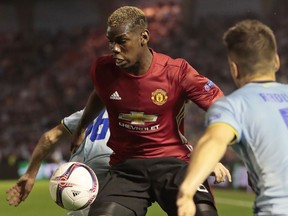 Manchester United's Paul Pogba, centre, tries to get past Celta's Nemanja Radoja, right, during a Europa League semifinal, first-leg match at the Balaidos stadium in Vigo, Spain, on May 4.