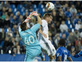 Vancouver Whitecaps forward Kyle Greig heads the ball away from Montreal Impact goalkeeper Maxime Crepeau during the second leg of the Canadian Championship semifinal on Tuesday in Montreal.