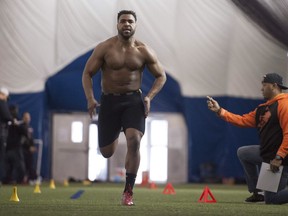 Justin Herdman, with an assist Geroy Simon, right, runs through drills for scouts during a pro day in March. Herdman was drafted by the Toronto Argonauts, while his brother Jordan was taken by the B.C. Lions.