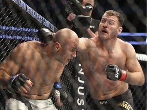 Stipe Miocic, lands a right against Junior Dos Santos in a mixed martial arts bout at UFC 211 for the UFC heavyweight championship, Saturday, May 13, 2017, in Dallas. Miocic retained his heavyweight title.