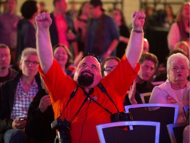 An NDP supporter raises his arms in celebration while watching results at NDP election night headquarters in Vancouver, B.C., on Tuesday May 9, 2017.
