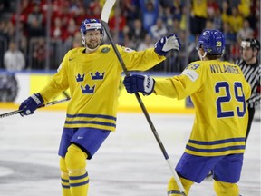 Sweden's Alexander Edler, left, celebrates with William Nylander after scoring the opening goal at the Ice Hockey World Championships semifinal match between Sweden and Finland in the LANXESS arena in Cologne, Germany on Saturday. Sweden won 4-1. Edler has two goals and two assists in the tournament, and will lead Sweden into the gold medal game against Canada.