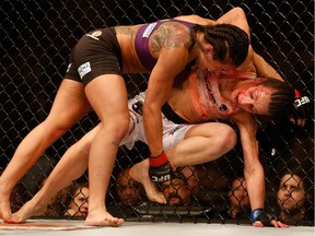 Claudia Gadelha, top, tries a takedown on Joanna Jedrzejczyk in their women's strawweight bout during UFC Fight Night at the U.S. Airways Center on Dec. 13, 2014, in Phoenix.
