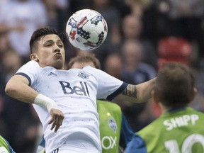 Whitecaps Fredy Montero, left, fights for control of the ball against Seattle Sounders Harry Shipp during an MLS game in Vancouver on April 14.