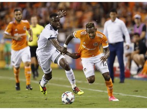 Midfielder Tony Tchani of the Vancouver Whitecaps grabs the jersey of Houston Dynamo forward Romell Quioto during Friday's 2-1 setback in Major League Soccer action in Texas.