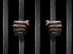 [PNG Merlin Archive] photo illustration of hands grasping prison bars. iStockphoto with modifications